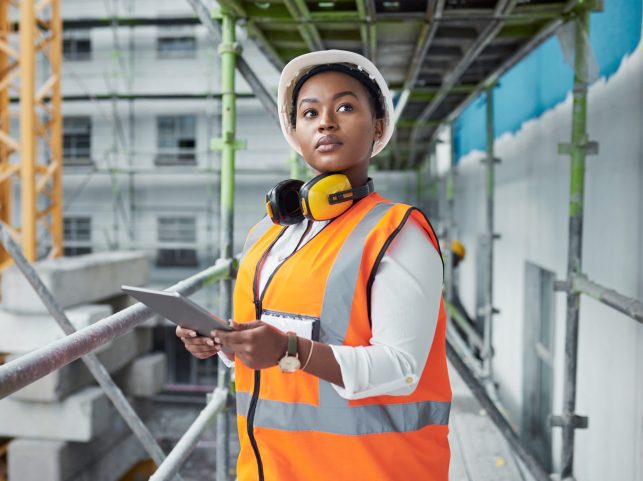 Shot of a young woman using a digital tablet while working at a construction site.