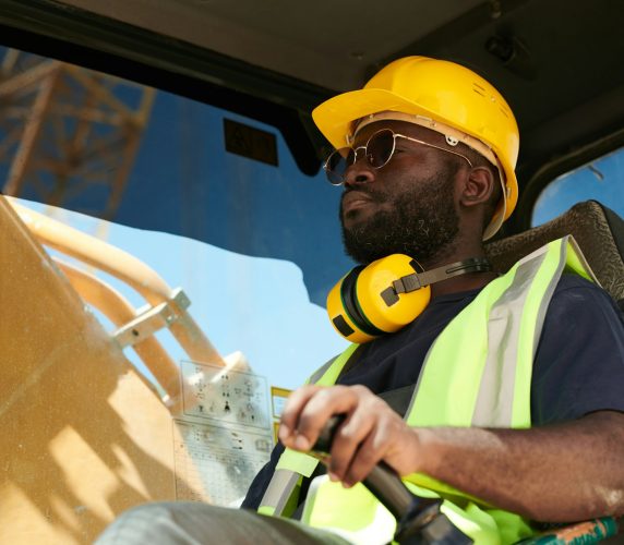 young-black-male-driver-of-construction-machine-in-safety-helmet-and-uniform